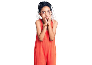 Şirin Afro-Amerikan kızı günlük kıyafetler giyiyor. Yorgun elleri var. Yüzü, depresyonu ve üzüntüyü örtüyor. 