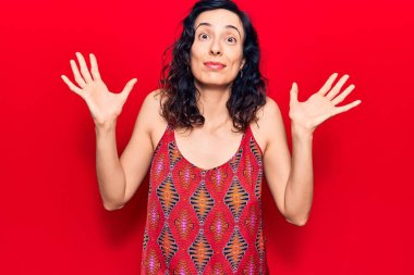 Gündelik kıyafetler giyen, kolları açık ve kafası karışmış, hiçbir fikri olmayan, kuşkulu yüzlü, genç ve güzel İspanyol bir kadın.. 