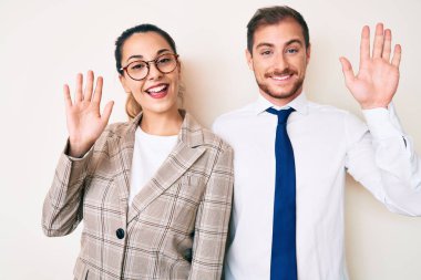 İş kıyafetleri giymiş güzel bir çift merhaba diyor mutlu ve gülümsüyor, dostça karşılama jesti. 