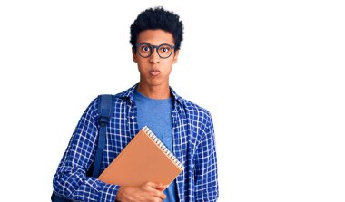 Sırt çantası takan, kitap şişiren komik yüzlü, Afro-Amerikalı genç bir adam. Havayla şişmiş ağız, çılgın bir ifade.. 