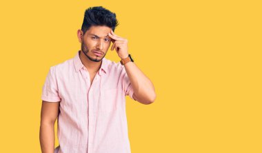 Yakışıklı Latin Amerikalı sıradan bir yaz gömleği giyen genç adam. Alnındaki sorun yüzünden endişeli ve stresli. Kriz için endişeli. 