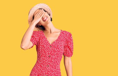 Yaz şapkası takan, gülümseyen ve gülen genç ve güzel bir kadın şaşırtmak için gözlerini kapatıyor. kör kavram. 