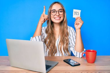 Genç, güzel, sarışın bir kadın elinde evet hatırlatıcı bir fikirle masada oturuyor ya da bir soru işareti yaparak gülümsüyor, bir numara: 