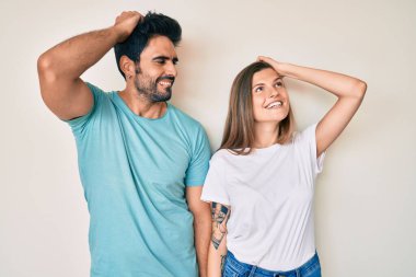 Güzel, genç bir çift sevgili birlikte gülümsüyor. Kendine güvenen, el hareketleriyle saçlara dokunan, çekici ve modaya uygun poz veren. 