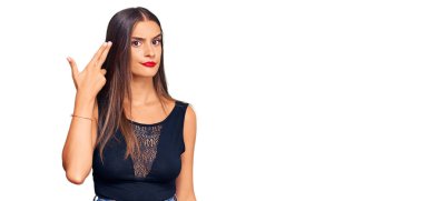 Gündelik giysiler giymiş genç İspanyol bir kadın silah gibi elini ve parmaklarını havaya kaldırarak kendini vuruyor, intihar ediyor.. 