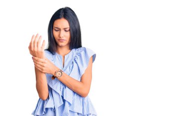 Genç ve güzel Latin kız gündelik kıyafetler giyiyor. Ellerinde ve parmaklarında ağrı var. Eklem iltihabı. 