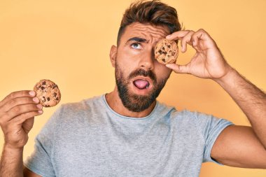 Genç İspanyol adam elinde kurabiyeyle kızgın ve kızgın bağırıyor sinirlenmiş ve öfkeli, öfkeyle bağırıyor.. 