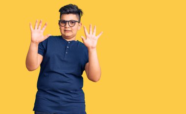 Günlük kıyafetler ve gözlük takan küçük çocuk korku ifadesinden korkmuş ve dehşete düşmüş. El hareketlerini bırak, şok içinde bağır. panik konsepti. 