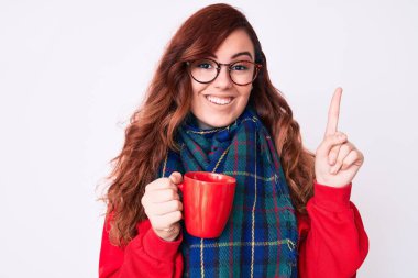 Kış eşarbı takan ve bir fincan sıcak kahve içen genç ve güzel bir kadın bir fikir ya da soru işareti ile şaşırdı. 