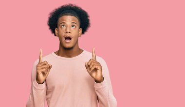 Afro saçlı Afrikalı bir adam. Günlük kıyafetlerini giymiş. Şaşırmış ve şaşırmış.. 