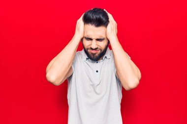 Sakallı, sıradan polo giyen, baş ağrısı çeken, çaresiz ve stresli genç bir adam. Çünkü acı ve migren ağrısı var. Eller başının üstünde.. 