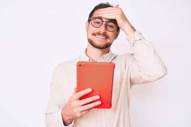 Dokunmatik ped kullanan genç yakışıklı adam elleri kafasında, şaşırmış ve sinirli yüzüyle stresli ve hayal kırıklığına uğramış. 