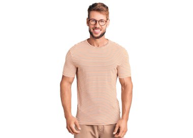 Yüzünde mutlu ve havalı bir gülümseme olan günlük kıyafetler ve gözlük takan genç beyaz bir adam. şanslı kişi. 