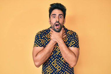 80 'lerin disko tarzı tişörtlü yakışıklı İspanyol adam bağırıyor ve boğuluyor çünkü acı verici bir boğulma. Sağlık problemi. Boğulma ve intihar konsepti. 