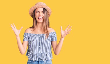 Şapka ve tişört giyen genç ve güzel bir kız. Deli gibi bağırıyor ve agresif bir ifade ve kollarla bağırıyor. hüsran kavramı. 