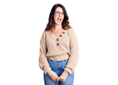 Güzel, genç, esmer, sıradan kıyafetler ve gözlük takan bir kadın kameraya seksi bir ifadeyle bakıyor, neşeli ve mutlu bir yüzle.. 