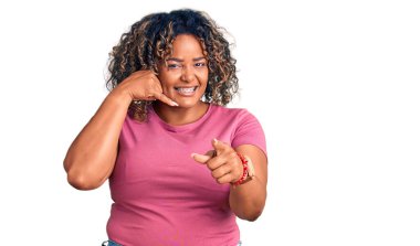 Genç Afro-Amerikan artı cüsseli kadın günlük kıyafetler giyiyor gülümsüyor telefonda konuşuyor ve seni işaret ediyor. Ara beni.. 