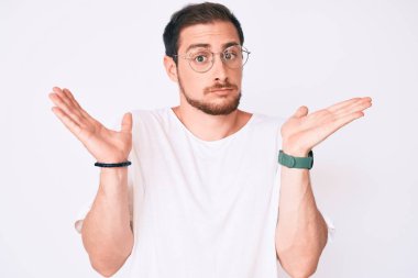 Gündelik kıyafetler giyen, gözlüklü, kafası karışık ve kolları açık genç bir adam, hiçbir fikrim yok.. 