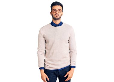 Zarif kıyafetler giyen ve gözlüklü, komik yüzlü, yanak şişiren genç, yakışıklı İspanyol adam. Havayla şişmiş ağız, çılgın bir ifade.. 