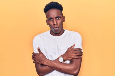 Genç, Afro-Amerikan bir adam günlük giysiler giyiyor. Kış soğuğu için titriyor ve donuyor. Yüzünde üzgün ve şok ifadesi var. 