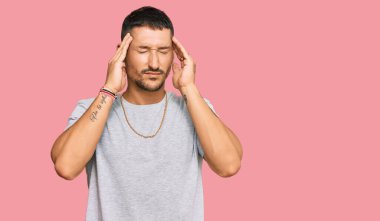 90 'lı yılların stili dövmeleri olan yakışıklı bir adam. Stres yüzünden başı ağrıyan eller. migren ağrısı. 