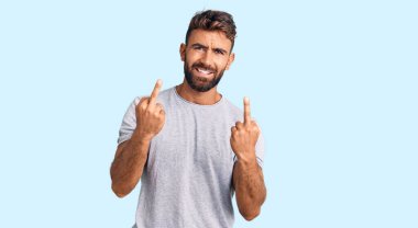 Young hispanic man wearing casual clothes showing middle finger doing fuck you bad expression, provocation and rude attitude. screaming excited 
