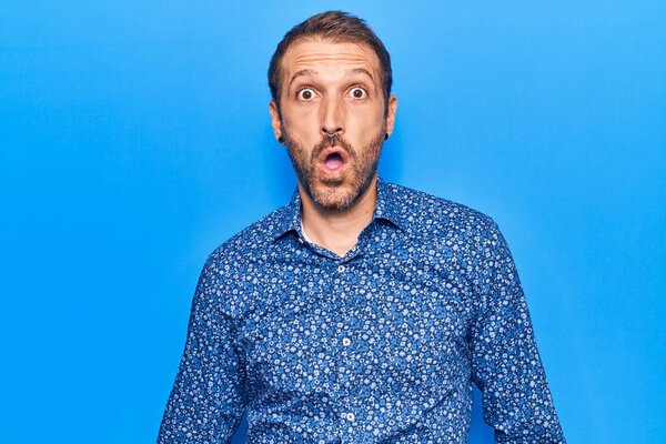 Молодой красивый мужчина в повседневной одежде напуган и поражен с открытым ртом для удивления, неверие лицо 