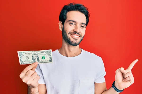Νεαρός Ισπανός Που Κρατάει Χαρτονόμισμα Του Ενός Δολαρίου Χαμογελώντας Χαρούμενος — Φωτογραφία Αρχείου