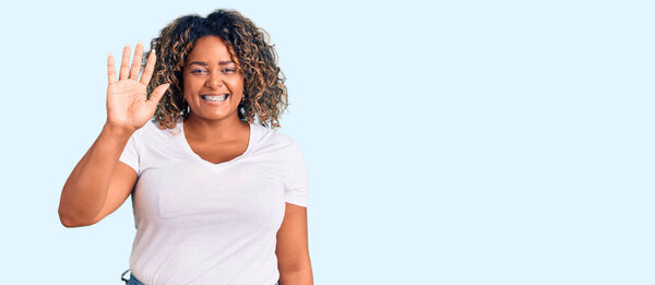Young african american plus size woman wearing casual clothes showing and pointing up with fingers number five while smiling confident and happy. 