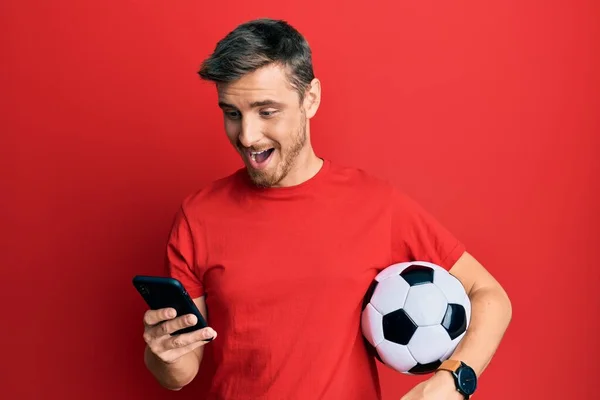 Jóképű Kaukázusi Férfi Kezében Futball Labda Nézi Smartphone Ünneplő Őrült — Stock Fotó