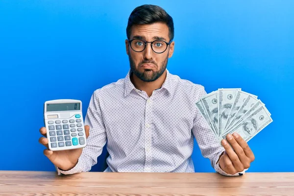 Handsome Hispanic Man Holding Dollars Calculating Savings Depressed Worry Distress — Stock Photo, Image