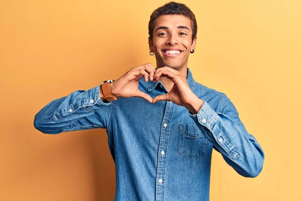 手でハートのシンボルの形をする愛に笑顔カジュアルな服を着ている若いアフリカ系アメリカ人男性 ロマンチックなコンセプト — ストック写真