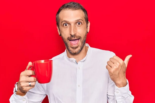 Young Handsome Man Holding Coffee Pointing Thumb Side Smiling Happy — Stock Photo, Image