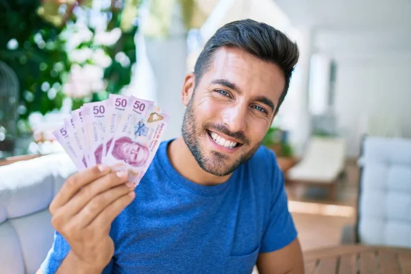 Joven Hispano Sonriendo Feliz Sosteniendo Billetes Mexicanos Terraza — Foto de Stock