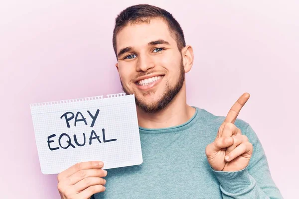 Jovem Homem Bonito Segurando Salário Papel Igual Sorrindo Feliz Apontando — Fotografia de Stock