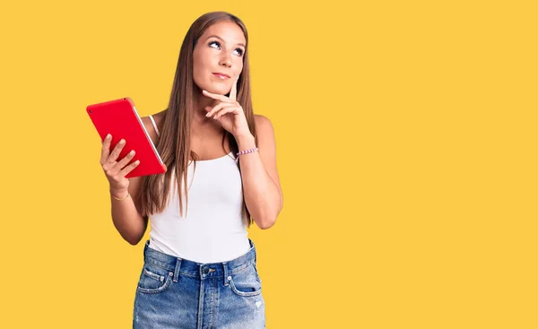 Mujer Hispana Hermosa Joven Sosteniendo Touchpad Cara Seria Pensando Pregunta — Foto de Stock