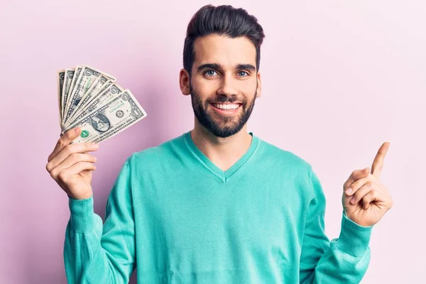 Joven Hombre Guapo Con Barba Sosteniendo Manojo Dólar Sonriendo Feliz —  Fotos de Stock
