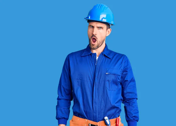 Jovem Homem Bonito Vestindo Uniforme Trabalhador Chapéu Duro Confundir Perguntando — Fotografia de Stock