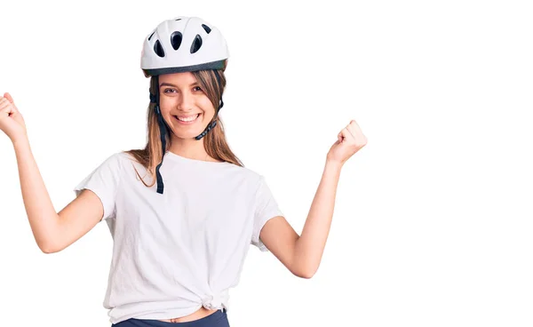 年轻美丽的女孩戴着自行车头盔 自豪地尖叫着 高举双臂庆祝胜利和成功 — 图库照片