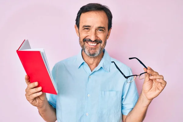 Hombre Hispano Mediana Edad Leyendo Libro Con Gafas Sonriendo Con —  Fotos de Stock