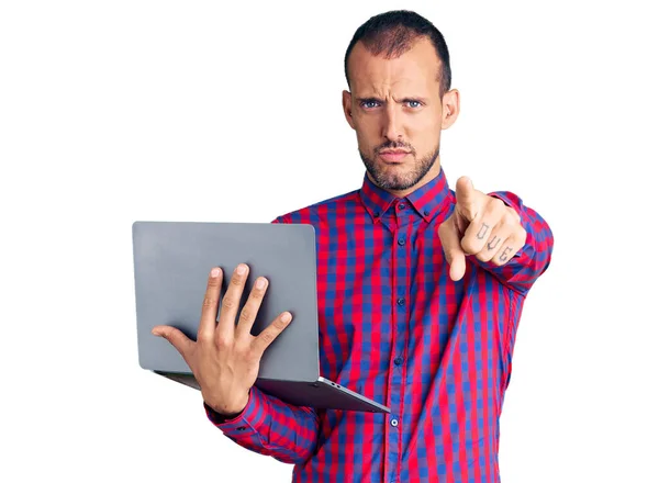 年轻英俊的男人用电脑笔记本电脑 用手指着相机和你 自信而严肃地摆出一副姿势 — 图库照片