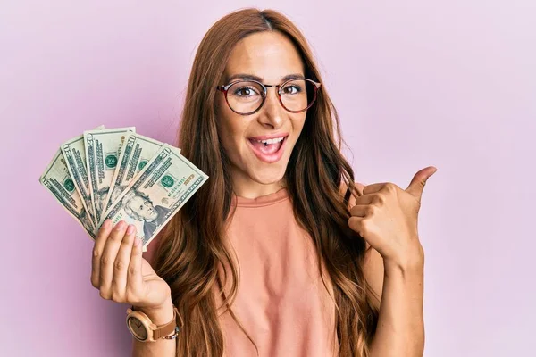 Ung Brunett Kvinna Håller Dollar Pekar Tummen Upp Till Sidan — Stockfoto