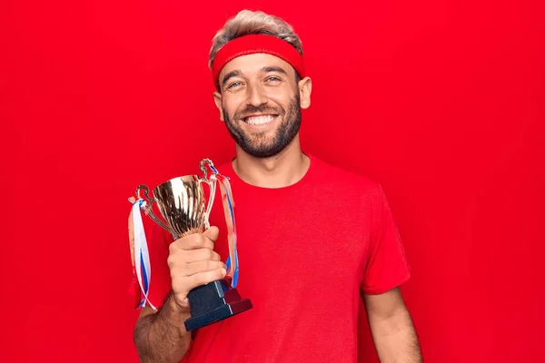 Giovane Sportivo Biondo Bello Con Barba Vincente Trofeo Sfondo Rosso — Foto Stock