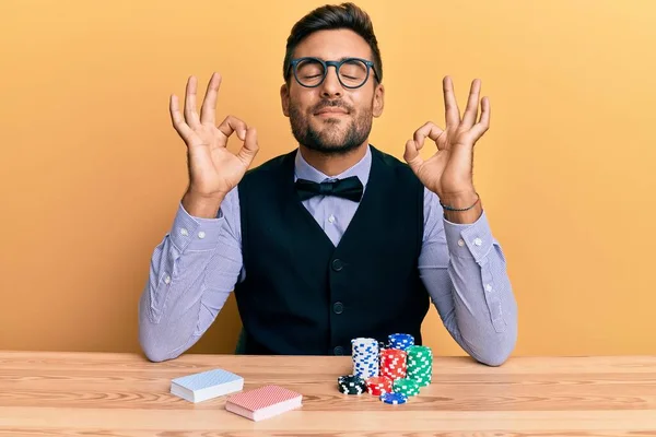 Masada Poker Fişleri Kartlarla Oturan Yakışıklı Spanyol Krupiye Rahatlayıp Gözleri — Stok fotoğraf