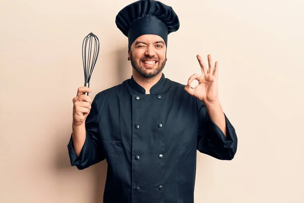 Joven Hombre Hispano Con Uniforme Cocina Sosteniendo Batidor Haciendo Signo — Foto de Stock