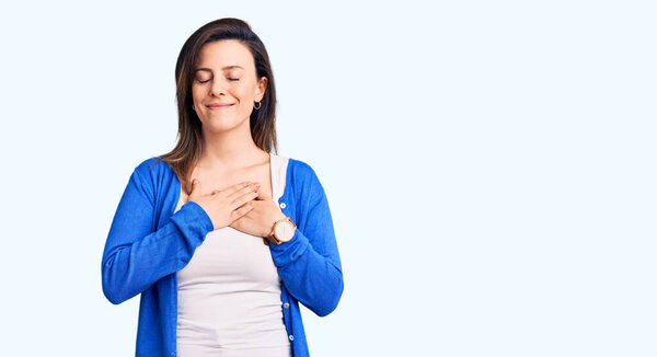 Молодая красивая женщина в повседневной одежде улыбается с закрытыми глазами и благодарным жестом на лице. концепция здоровья. 