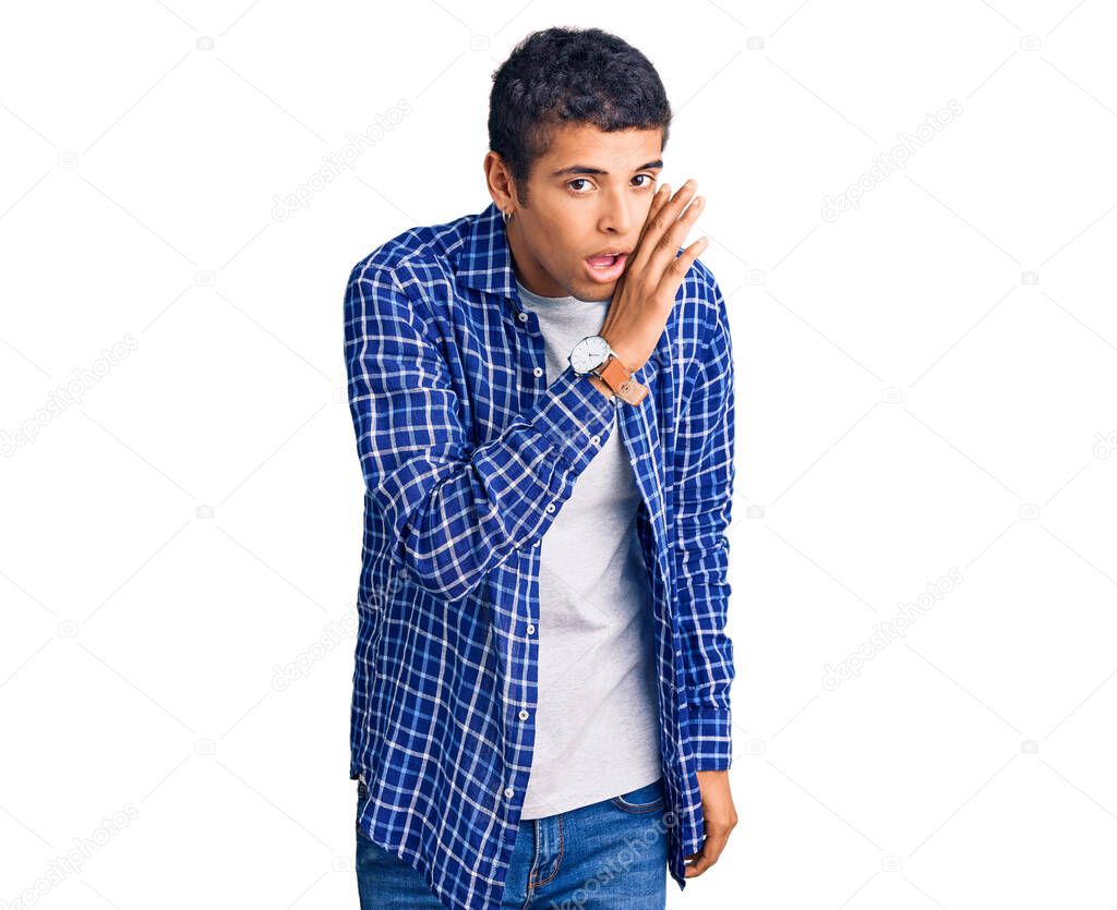Young african amercian man wearing casual clothes hand on mouth telling secret rumor, whispering malicious talk conversation 