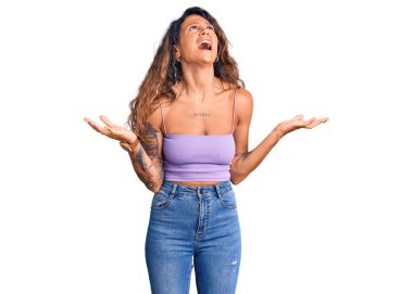 Dövmeli genç İspanyol kadın. Günlük kıyafetler giyiyor. Deli gibi bağırıyor, agresif bir ifadeyle bağırıyor ve kollarını kaldırıyor. hüsran kavramı. 