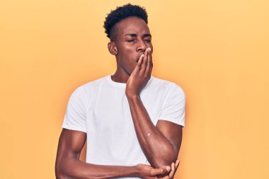 Gündelik giysiler giyen genç Afro-Amerikalı adam ağzını eliyle kapatmaktan sıkıldı. Huzursuz ve uykulu.. 