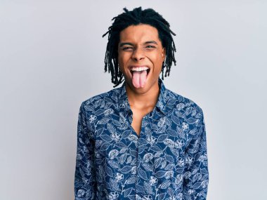 80 'lerin tarzında tişört giyen Afro-Amerikan genç adam komik bir ifadeyle dilini dışarı çıkarıyor. duygu kavramı. 